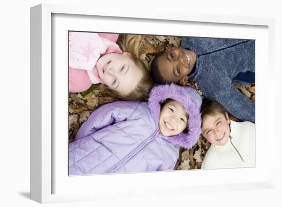 Smiling Children Lying on Autumn Leaves-Ian Boddy-Framed Photographic Print