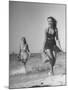 Smiling Girls Carrying Skis Out of the Water onto Beach-null-Mounted Photographic Print