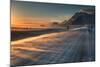 Snow Blows across an Icelandic Road at Sunrise with Mountains Looming in the Distance-Alex Saberi-Mounted Photographic Print