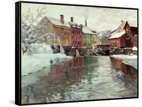 Snow-Covered Buildings by a River-Fritz Thaulow-Framed Stretched Canvas