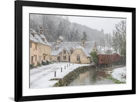 Snow covered houses by By Brook in Castle Combe with a dog enjoying a paddle, Wiltshire, England, U-Paul Porter-Framed Photographic Print