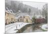 Snow covered houses by By Brook in Castle Combe with a dog enjoying a paddle, Wiltshire, England, U-Paul Porter-Mounted Photographic Print
