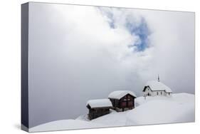 Snow Covered Mountain Huts and Church Surrounded by Low Clouds, Bettmeralp, District of Raron-Roberto Moiola-Stretched Canvas