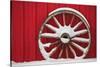 Snow-covered wagon wheels against red barn near town of Banff, Canadian Rockies, Alberta, Canada-Stuart Westmorland-Stretched Canvas