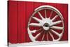 Snow-covered wagon wheels against red barn near town of Banff, Canadian Rockies, Alberta, Canada-Stuart Westmorland-Stretched Canvas