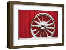 Snow-covered wagon wheels against red barn near town of Banff, Canadian Rockies, Alberta, Canada-Stuart Westmorland-Framed Photographic Print