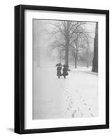 Snow Falling While People Take a Stroll Across Campus of Winchester College-Cornell Capa-Framed Photographic Print