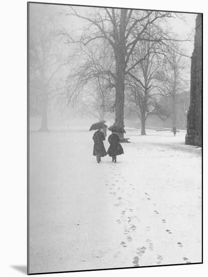 Snow Falling While People Take a Stroll Across Campus of Winchester College-Cornell Capa-Mounted Photographic Print