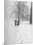 Snow Falling While People Take a Stroll Across Campus of Winchester College-Cornell Capa-Mounted Photographic Print