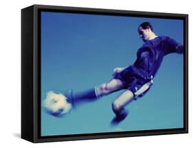 Soccer Player Jumping in Mid Air to Kick a Soccer Ball-null-Framed Stretched Canvas