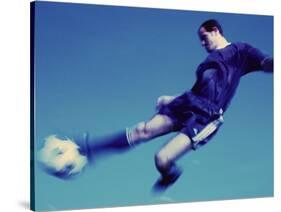 Soccer Player Jumping in Mid Air to Kick a Soccer Ball-null-Stretched Canvas