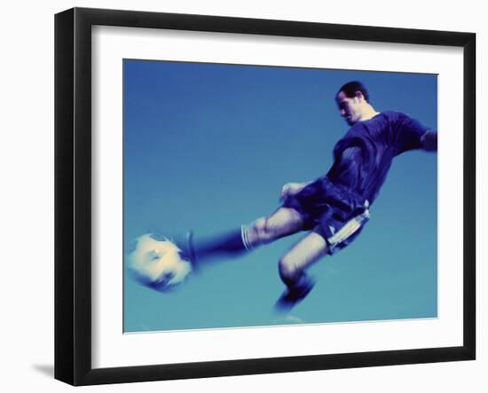 Soccer Player Jumping in Mid Air to Kick a Soccer Ball-null-Framed Premium Photographic Print
