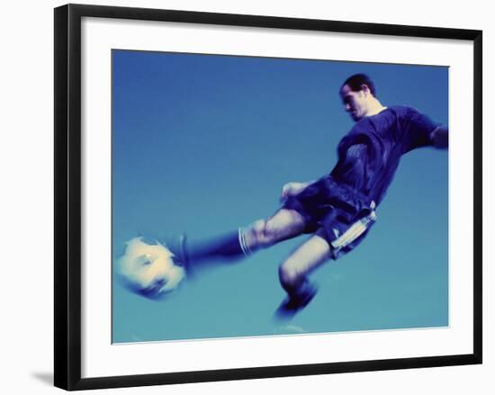 Soccer Player Jumping in Mid Air to Kick a Soccer Ball-null-Framed Photographic Print