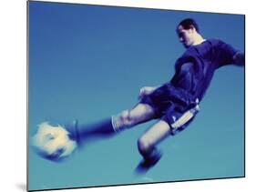 Soccer Player Jumping in Mid Air to Kick a Soccer Ball-null-Mounted Photographic Print