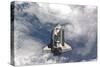 Space Shuttle Atlantis Above a Cloud Covered Earth-null-Stretched Canvas