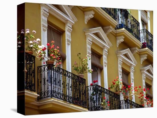 Spain, Sevilla, Andalucia Geraniums hang over iron balconies of traditional houses-Merrill Images-Stretched Canvas