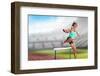 Sportswoman Practising the Hurdles against View of a Stadium-vectorfusionart-Framed Photographic Print