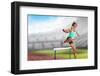 Sportswoman Practising the Hurdles against View of a Stadium-vectorfusionart-Framed Photographic Print