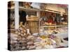 Stall Selling Cheese, Fruit Cake and Sausages at Christmas Market on Maxheinhardtplatz-Richard Nebesky-Stretched Canvas