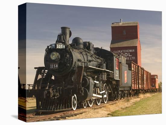 Steam Train and Grain Elevator in Western Development Museum, Saskatchewan, Canada-Walter Bibikow-Stretched Canvas