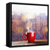 Steaming Cup of Coffee over a Cityscape Background-George D.-Framed Stretched Canvas