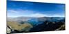 Steep sharp mountains, a deep blue lake, and mountain town in Queenstown, Otago, New Zealand-Logan Brown-Mounted Photographic Print