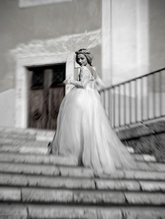 Young Adult Female in Long Wedding Dress Standing on Steps