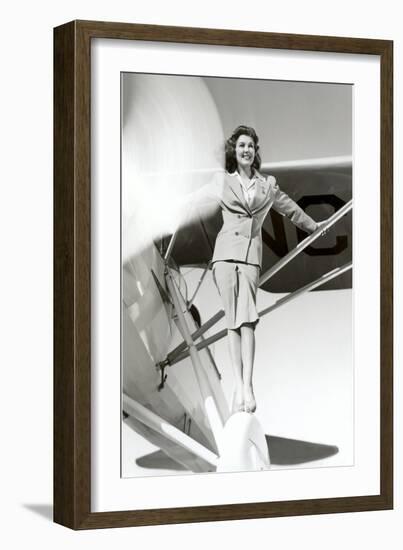 Stewardess Balancing on Plane Wheel-null-Framed Art Print