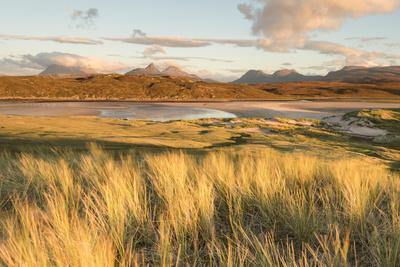 Sunlit Grass and Dunes at Achnahaird Bay and the Mountains of Assynt, North West Scotland