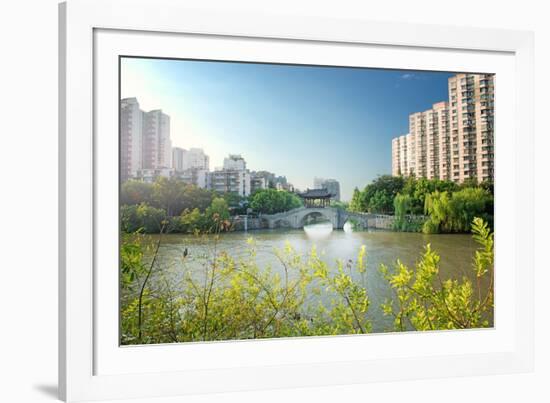 Stone bridge with pagoda style roofing, flanked by old style apartment buildings on the left and ne-Andreas Brandl-Framed Photographic Print