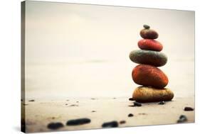 Stones Pyramid on Sand Symbolizing Zen, Harmony, Balance. Ocean in the Background-Michal Bednarek-Stretched Canvas
