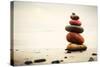 Stones Pyramid on Sand Symbolizing Zen, Harmony, Balance. Ocean in the Background-Michal Bednarek-Stretched Canvas