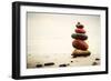 Stones Pyramid on Sand Symbolizing Zen, Harmony, Balance. Ocean in the Background-Michal Bednarek-Framed Photographic Print