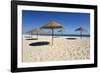 Straw umbrellas on empty white sand beach with clear sea behind, Ilha do Farol, Culatra Barrier Isl-Stuart Black-Framed Photographic Print