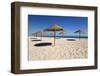 Straw umbrellas on empty white sand beach with clear sea behind, Ilha do Farol, Culatra Barrier Isl-Stuart Black-Framed Photographic Print