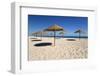 Straw umbrellas on empty white sand beach with clear sea behind, Ilha do Farol, Culatra Barrier Isl-Stuart Black-Framed Photographic Print