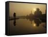 Stray Dog on a Sand Bank of the Yamuna River as the Sun is Seen Rising over the Taj Mahal in India-null-Framed Stretched Canvas