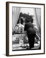 Suit Clad Movie Director Alfred Hitchcock as He Leans on Balcony Railing of Apartment-Peter Stackpole-Framed Premium Photographic Print