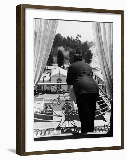 Suit Clad Movie Director Alfred Hitchcock as He Leans on Balcony Railing of Apartment-Peter Stackpole-Framed Premium Photographic Print