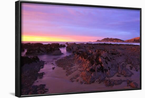 Sunrise Casts a Red Pink Hue on Rocks of a Beach Looking Towards Nugget Point-Eleanor-Framed Photographic Print