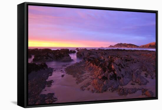 Sunrise Casts a Red Pink Hue on Rocks of a Beach Looking Towards Nugget Point-Eleanor-Framed Stretched Canvas