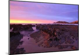 Sunrise Casts a Red Pink Hue on Rocks of a Beach Looking Towards Nugget Point-Eleanor-Mounted Photographic Print