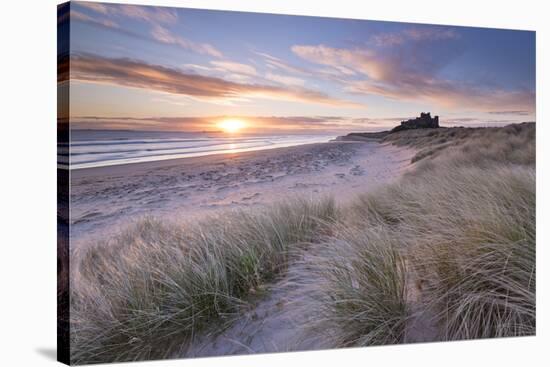 Sunrise over Bamburgh Beach and Castle from the Sand Dunes, Northumberland, England. Spring (March)-Adam Burton-Stretched Canvas