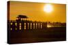 Sunset over the lake near wooden footbridge, Myanmar.-Michele Niles-Stretched Canvas