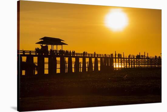Sunset over the lake near wooden footbridge, Myanmar.-Michele Niles-Stretched Canvas