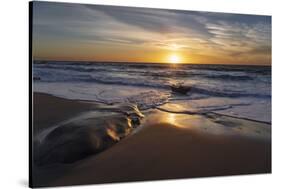 Sunset reflecting off the water on the sand of a beach-Sheila Haddad-Stretched Canvas