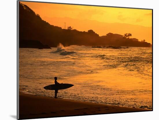 Surfer Standing at Waimea Bay at Sunset, Waimea, U.S.A.-Ann Cecil-Mounted Premium Photographic Print