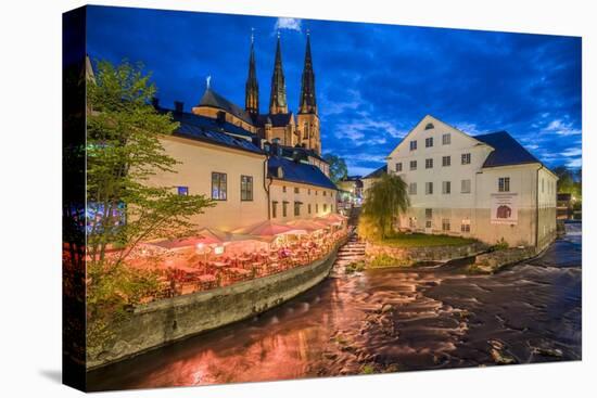 Sweden, Central Sweden, Uppsala, Domkyrka Cathedral with riverfront cafe, dusk-Walter Bibikow-Stretched Canvas