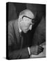 Swiss Architect Le Corbusier Leaning Down to Write with His Glasses Pushed Back on His Forehead-null-Stretched Canvas