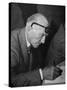 Swiss Architect Le Corbusier Leaning Down to Write with His Glasses Pushed Back on His Forehead-null-Stretched Canvas